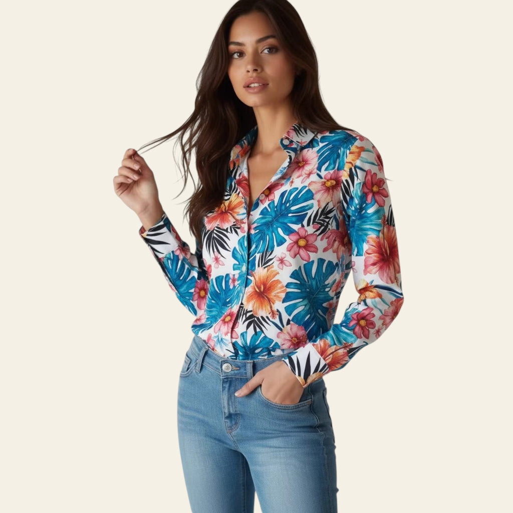 Woman wearing a colorful floral shirt and blue jeans against a plain background