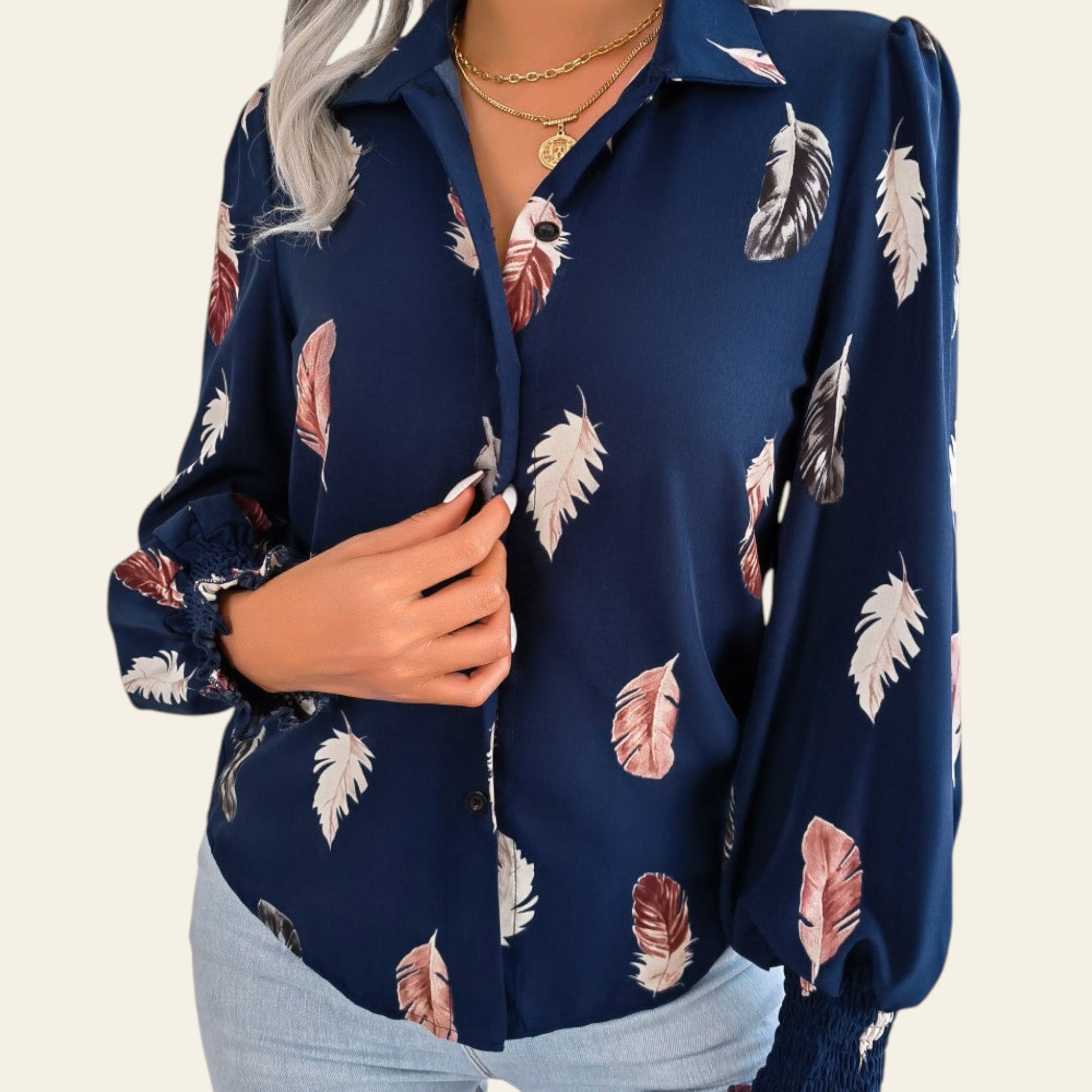 Navy blue blouse with feather pattern worn by a person on a white background