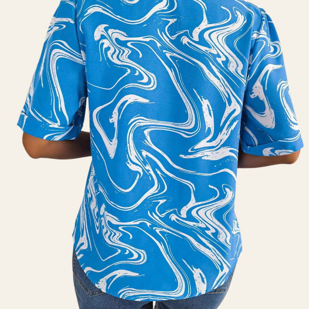 Person wearing a blue and white marbled patterned shirt sitting on a couch.