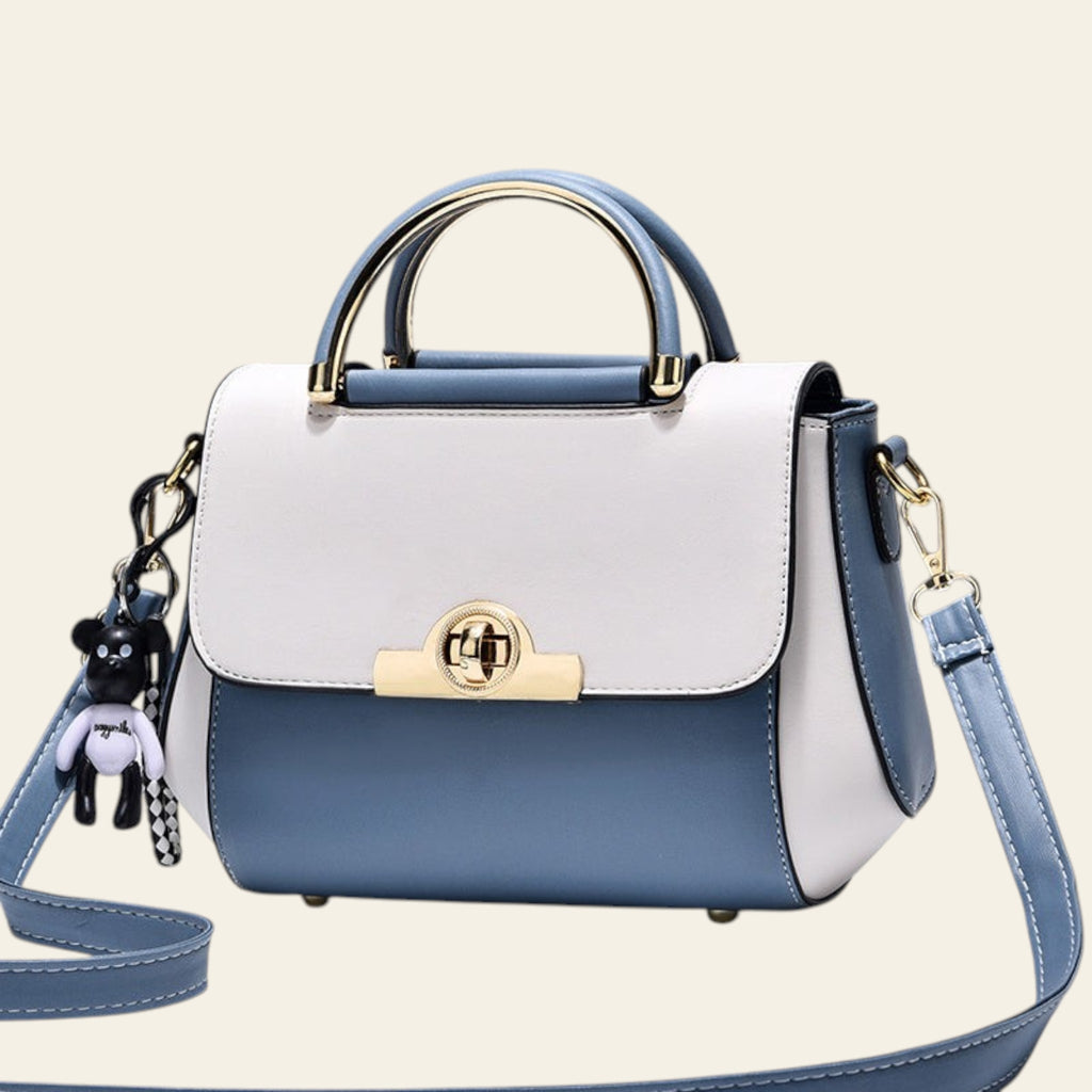 Blue and white handbag with gold accents on a light gray background