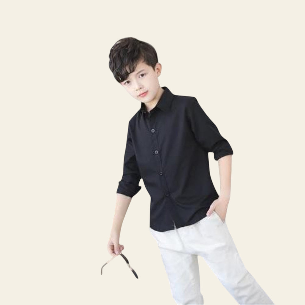 Child wearing a black shirt and white pants in an indoor setting