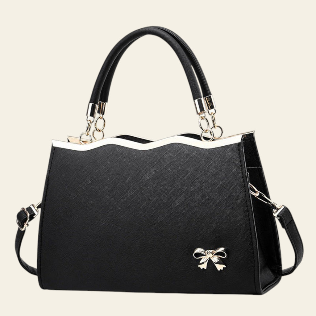 Black handbag with a bow detail on a white background