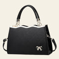 Black handbag with a bow detail on a white background