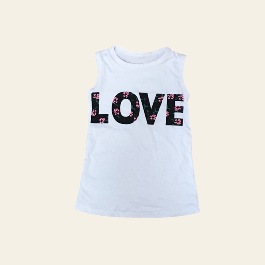 White tank top with 'LOVE' printed in black and pink on a wooden surface
