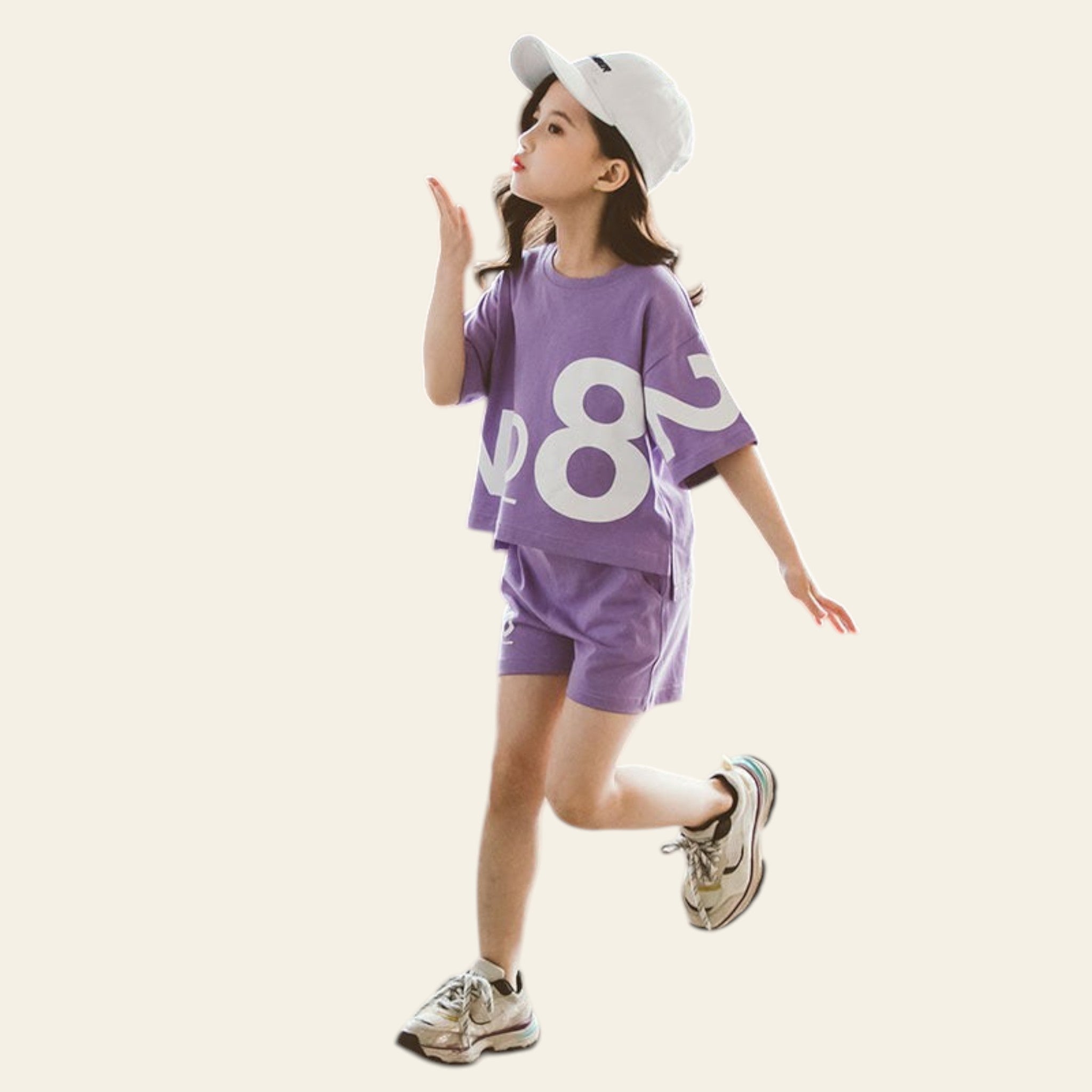 Child wearing a purple outfit with large numbers, standing on a concrete floor.