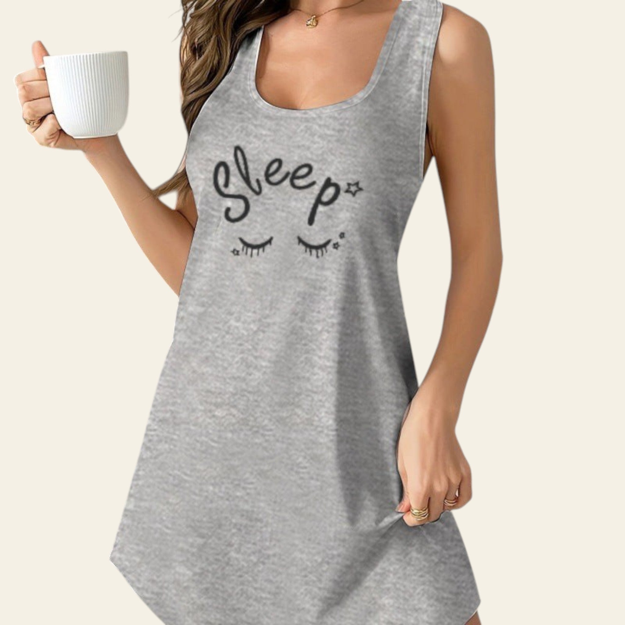 woman wearing a gray sleeveless casual dress with "Sleep" text print, holding a white mug indoors