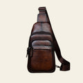 Brown leather sling bag on a wooden surface with a rustic background