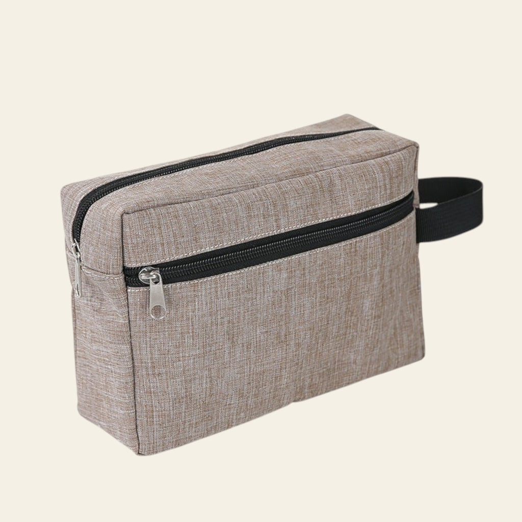 Beige toiletry bag with black zipper on a white background