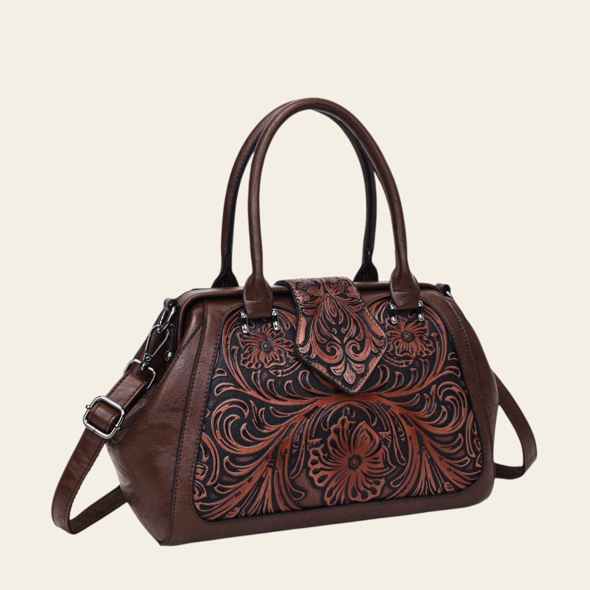 Brown leather handbag with intricate floral embossing on a white background