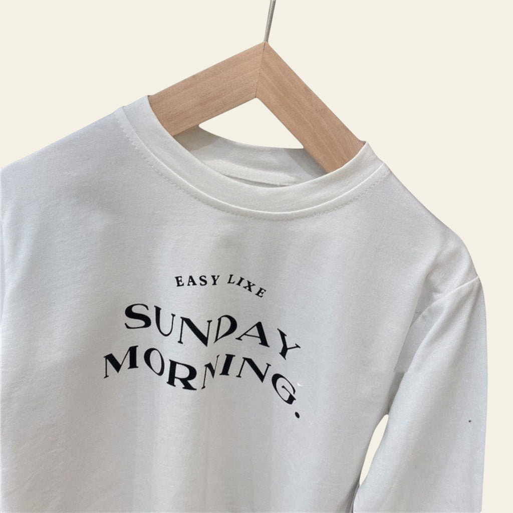 White sweatshirt with 'Easy Like Sunday Morning' text on a wooden hanger.