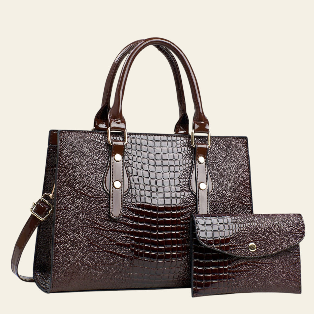 Brown crocodile-patterned handbag with matching pouch on a light gray background