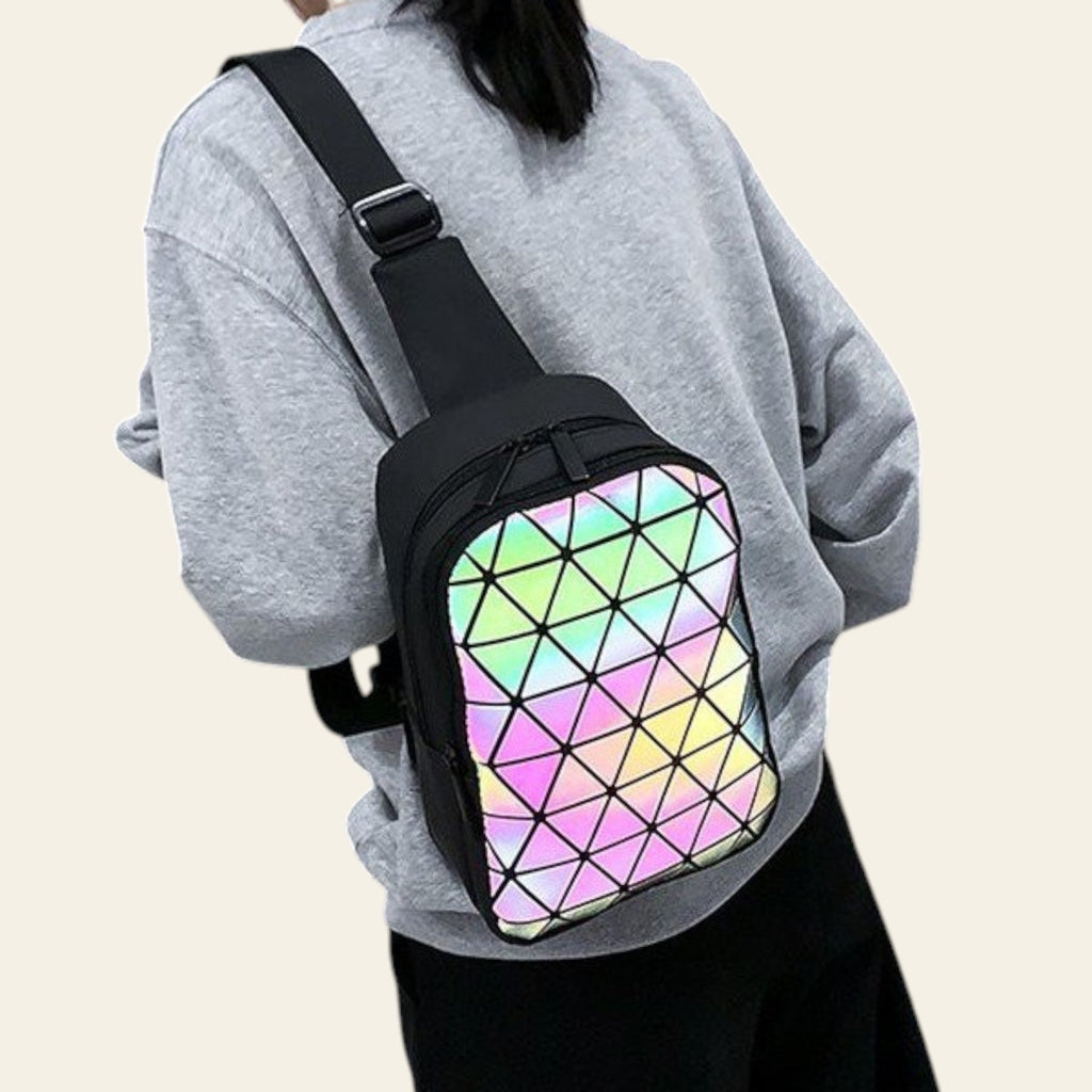 Person wearing a black crossbody bag with a colorful geometric pattern.