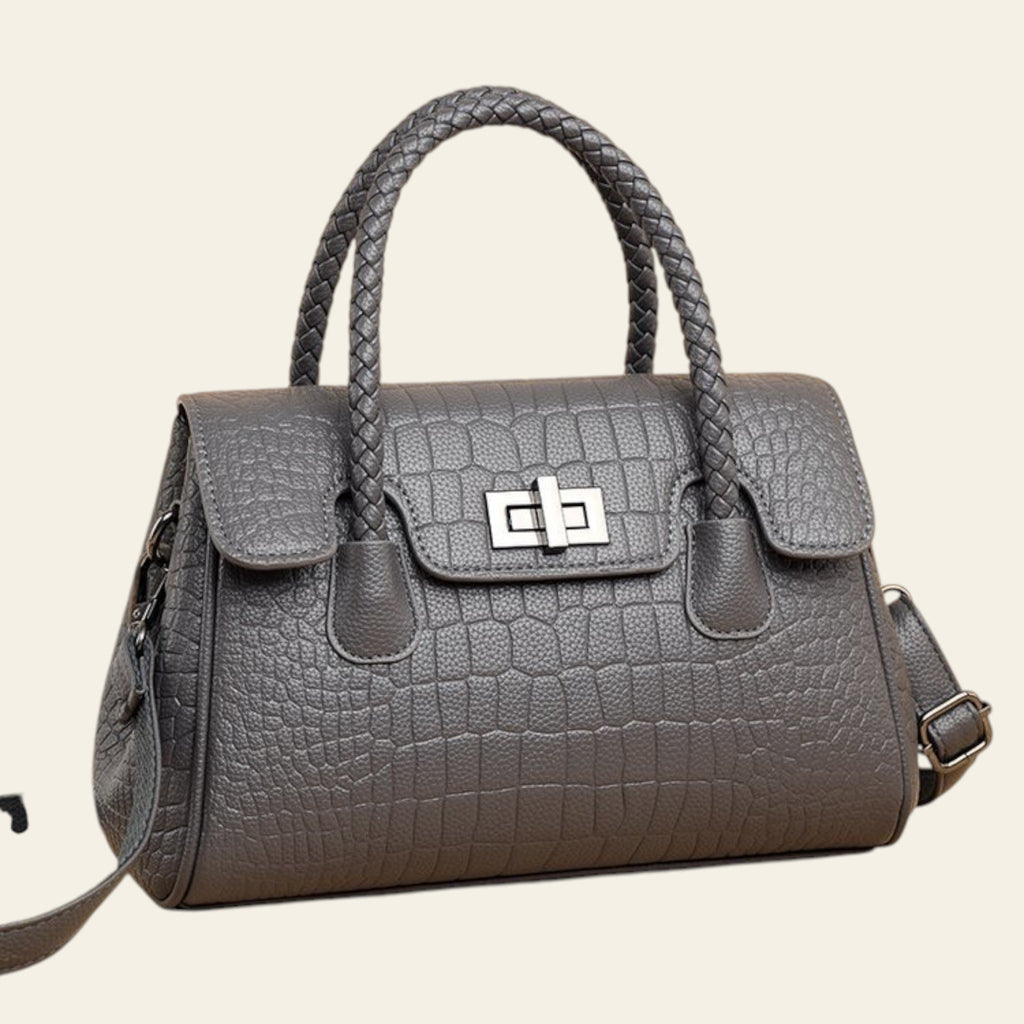 Gray textured handbag with braided handles on a beige background