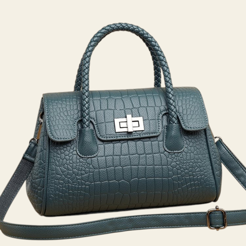 Blue textured handbag with braided handle on a beige background