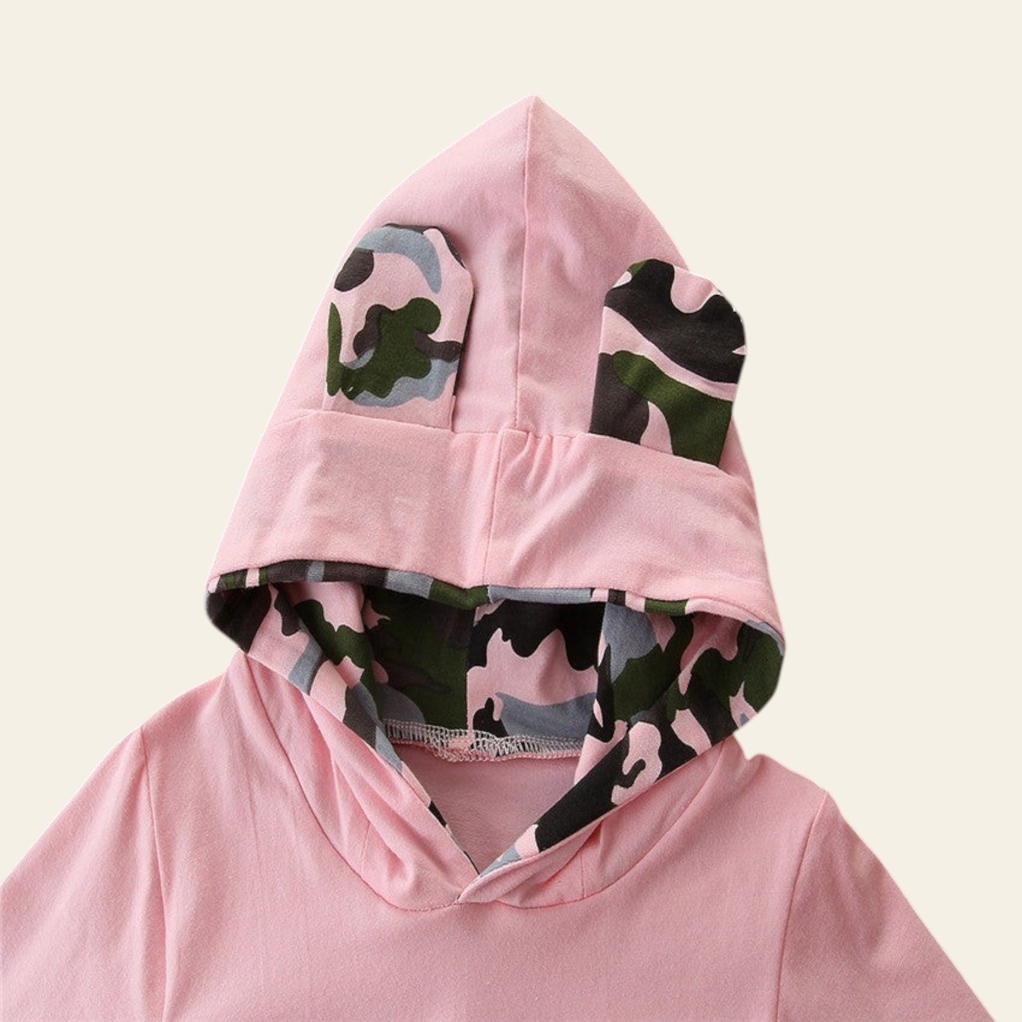 Pink hoodie with camouflage pattern on a wooden surface