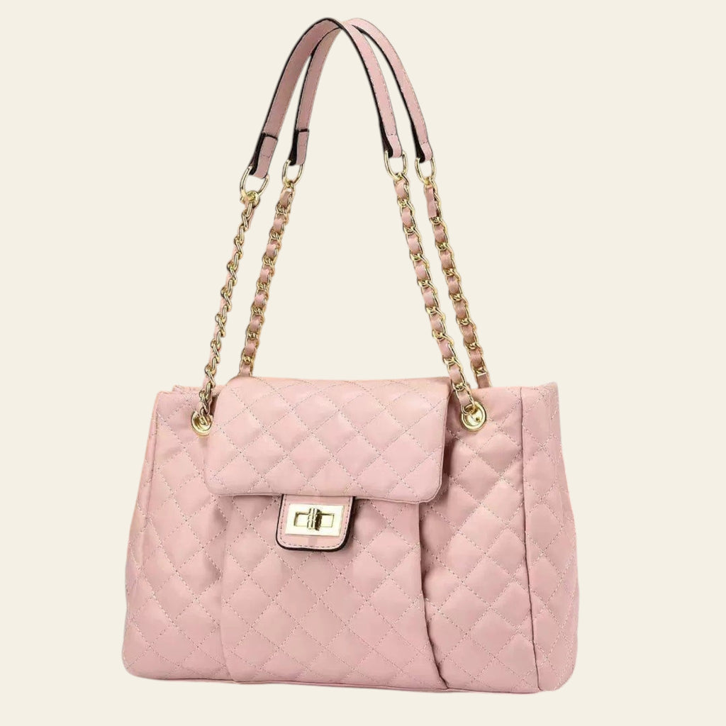 Pink quilted handbag with gold chain strap on a beige background