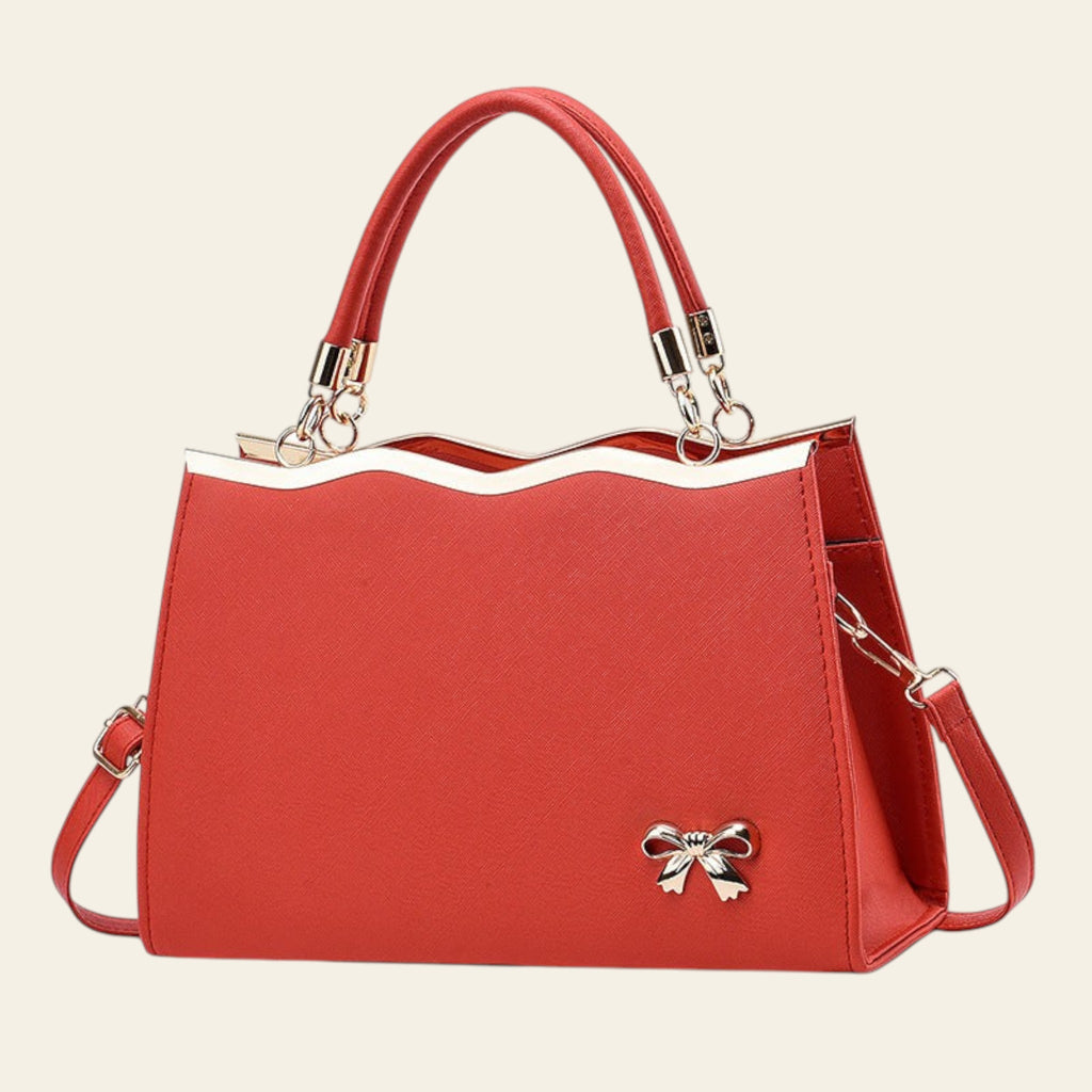 Red handbag with a bow detail on a white background