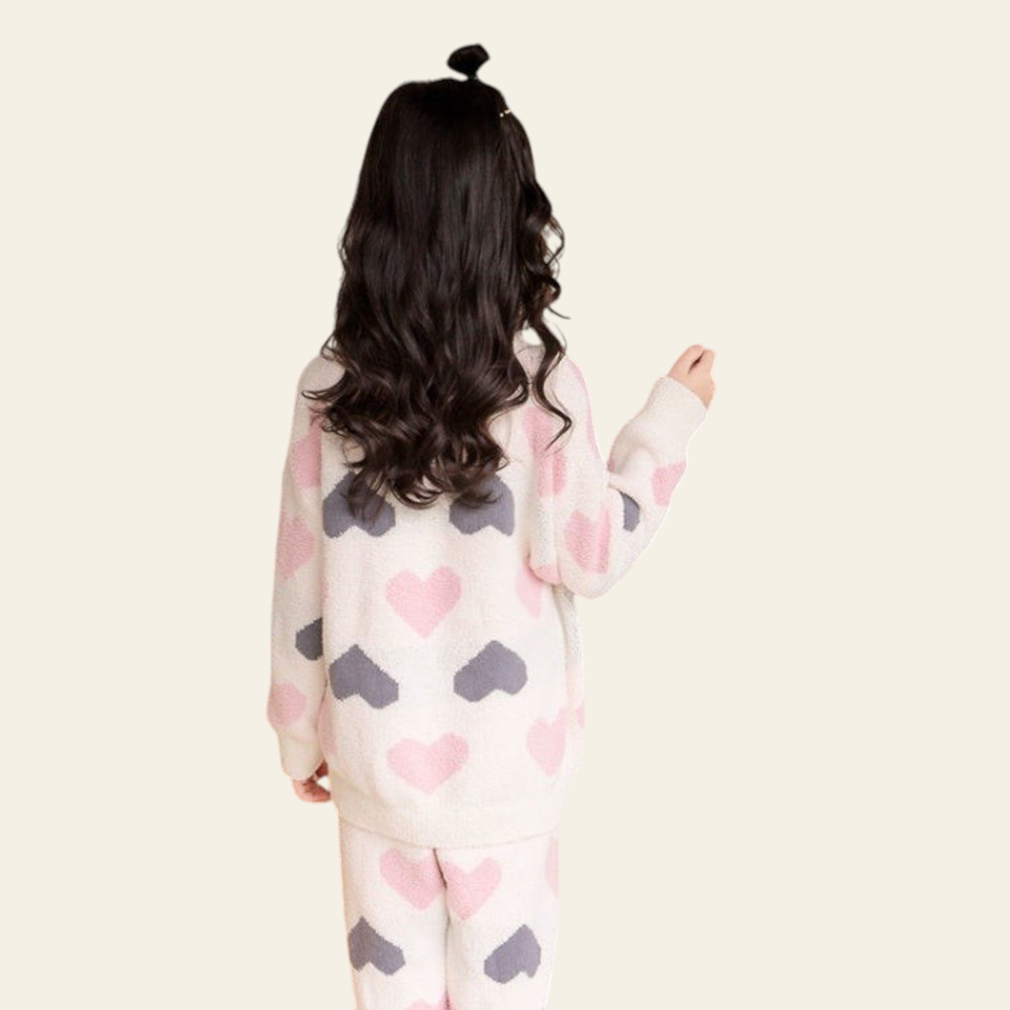 Child in a heart-patterned outfit standing inside a cozy indoor play area with a canopy.