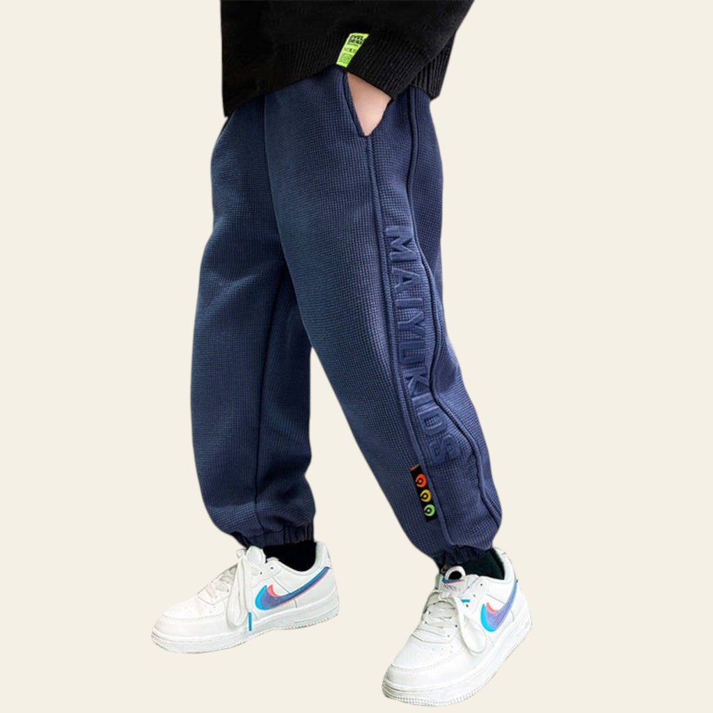 Navy blue jogger pants with colorful accents worn by a person on a white background