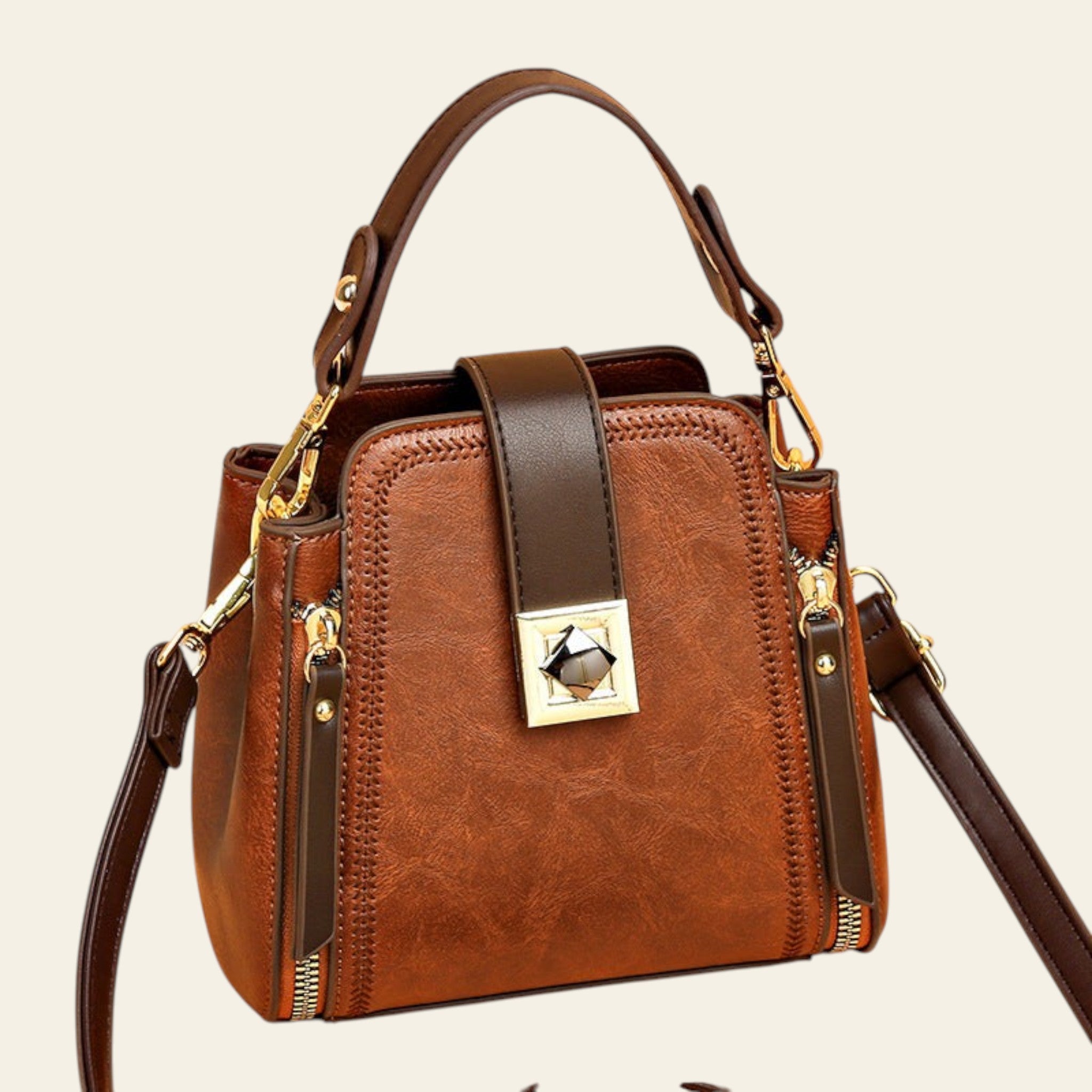 Brown leather handbag with gold accents on a beige background