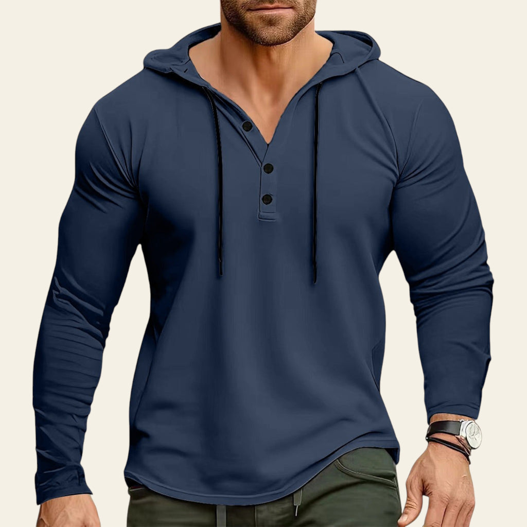 Man wearing a blue long-sleeve hoodie with a blurred background