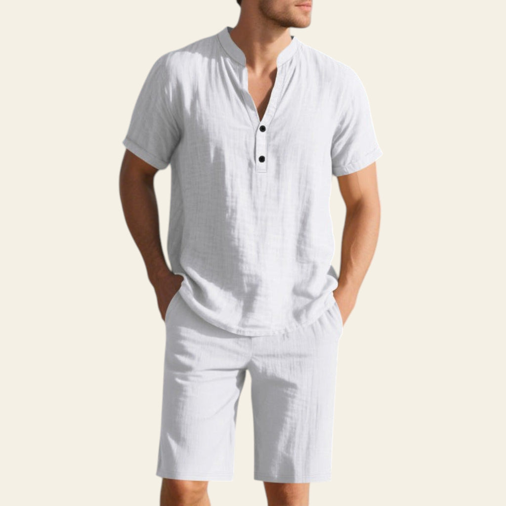 Man wearing a white linen summer shirt and shorts set on the beach