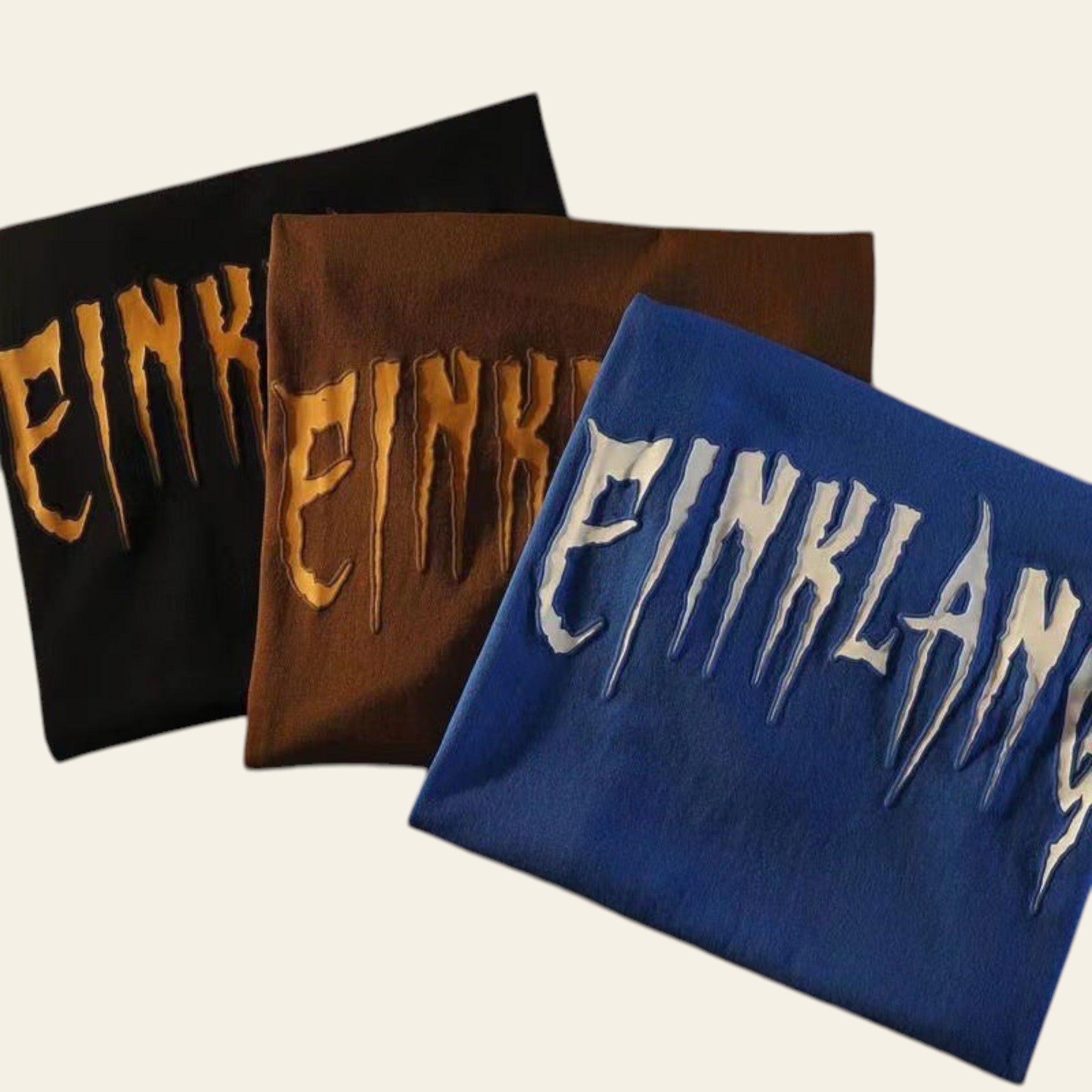 Three cloths with 'EINKLANG' text in different colors on a newspaper background