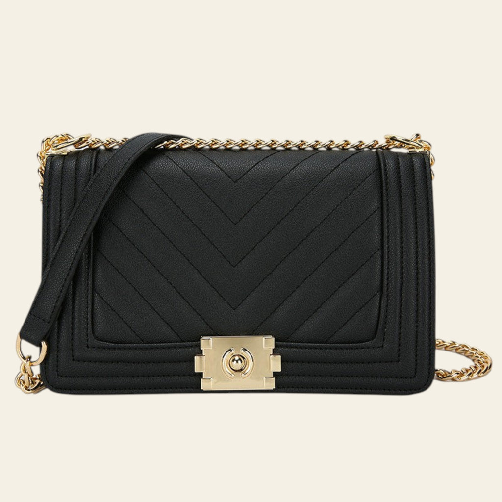 Black handbag with gold chain and clasp on a white background