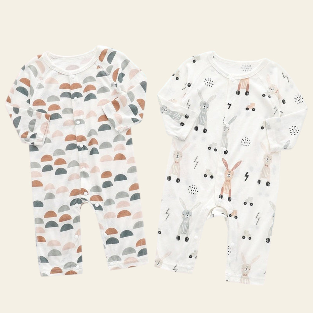 Two baby rompers with different patterns on a gradient background