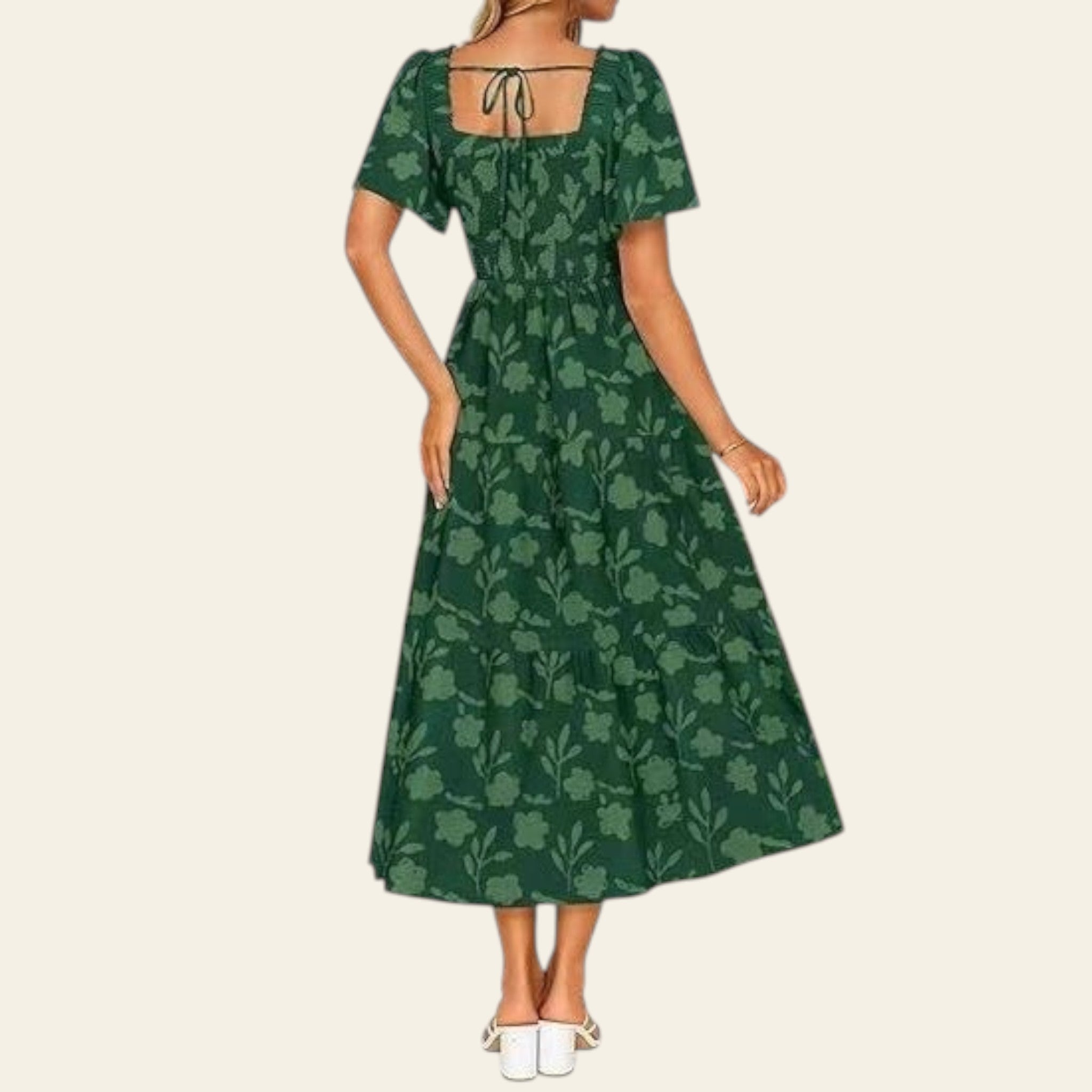 Green floral dress worn by a person with a blurred outdoor background