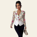Woman wearing a floral embroidered jacket over a white top and black pants, holding a beige handbag.