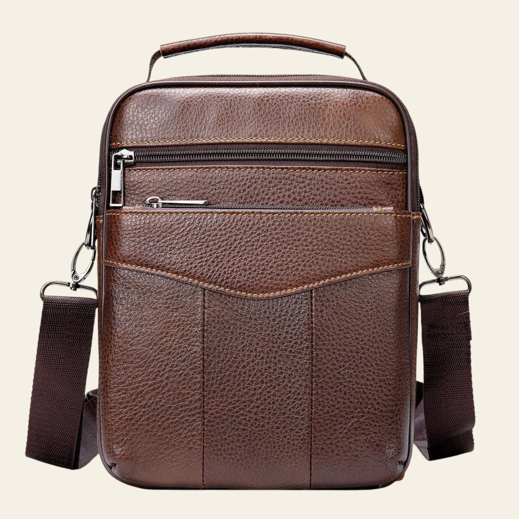Brown leather crossbody bag with a strap on a white background