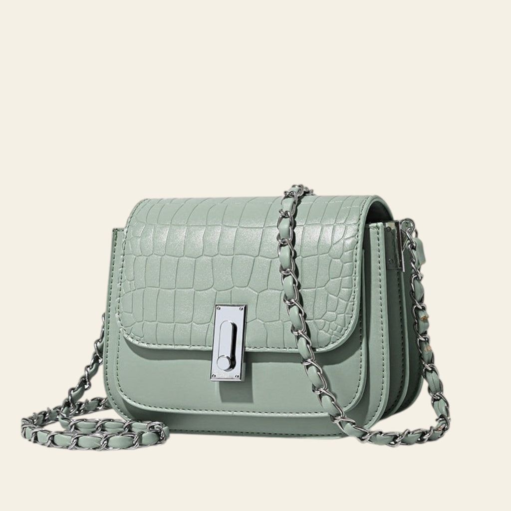 Mint green handbag with chain strap on a light beige background