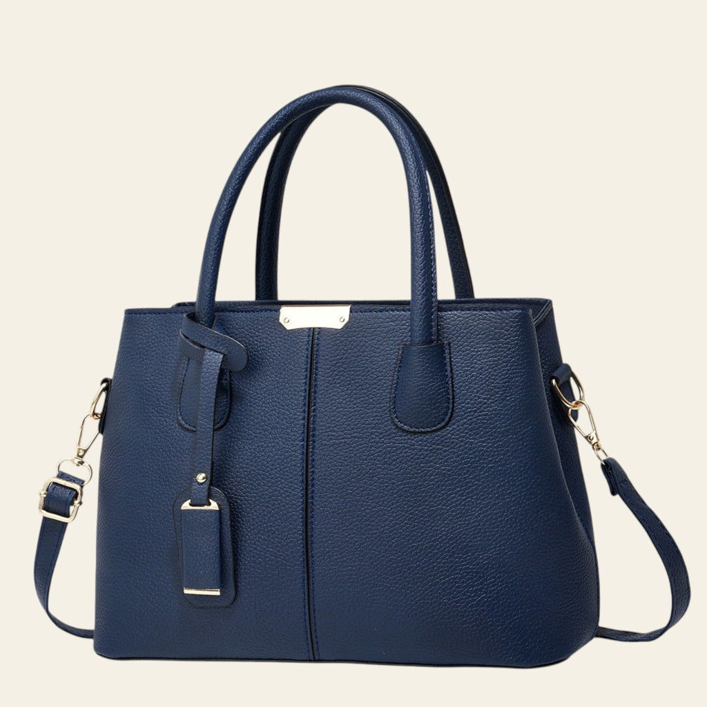 Blue handbag with gold accents on a white background