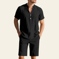 Man wearing a black casual linen two-piece outfit by the sea