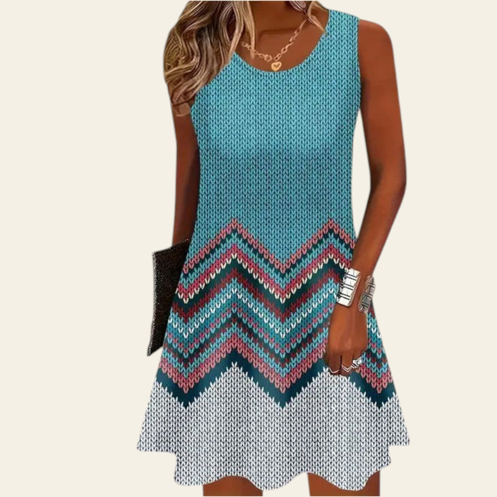 woman wearing a sleeveless turquoise dress with a multicolor zigzag knit pattern