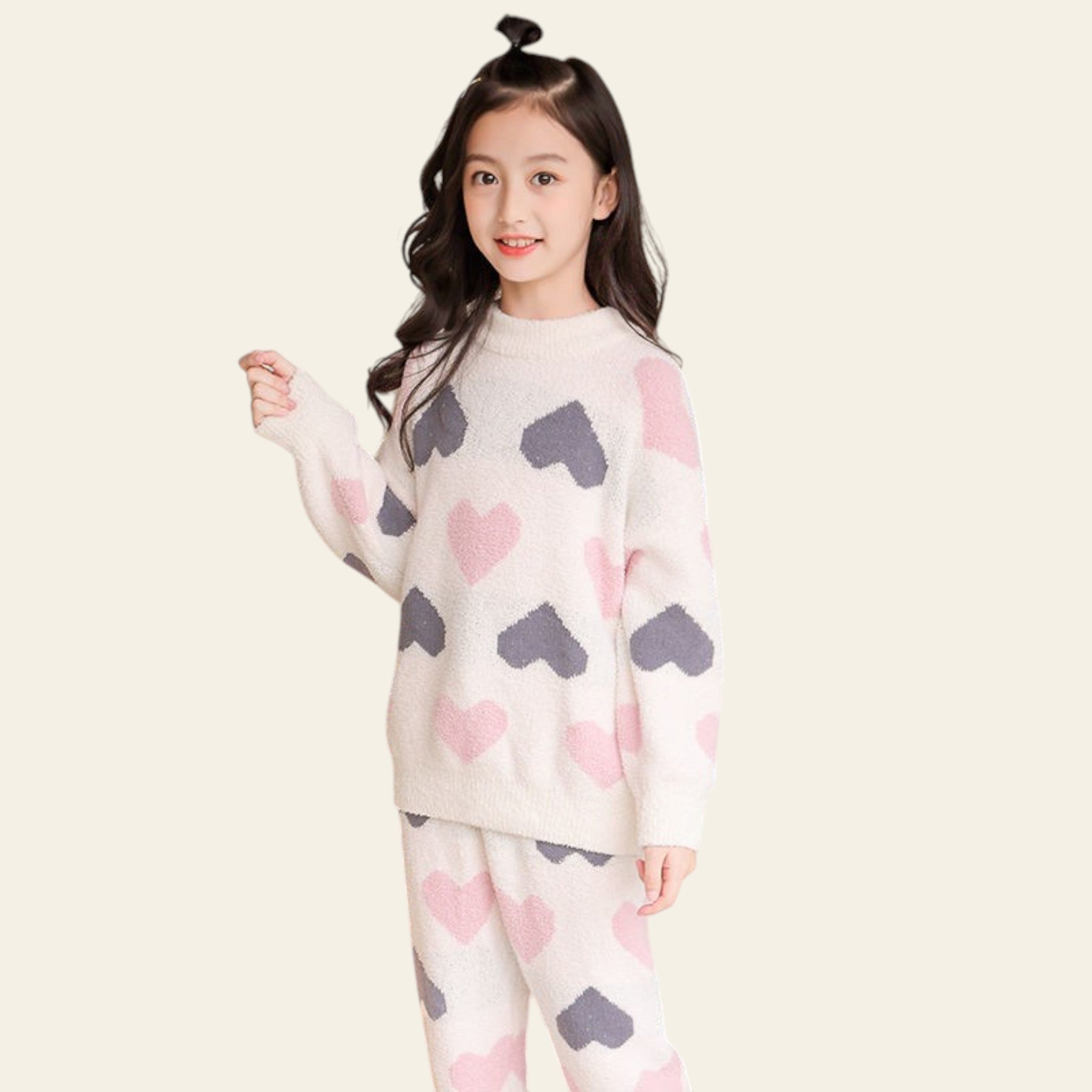 Young girl wearing a heart-patterned pajama set in a cozy bedroom.