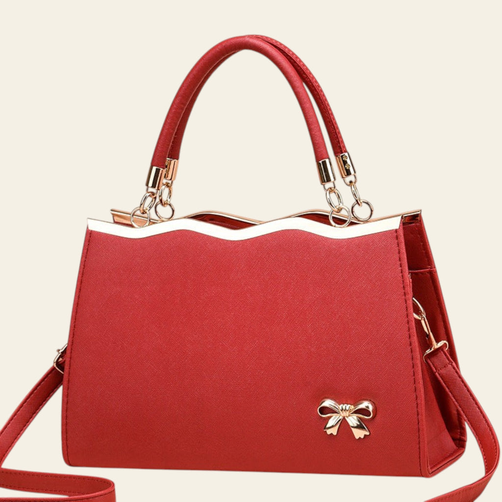 Red handbag with a bow detail on a beige background