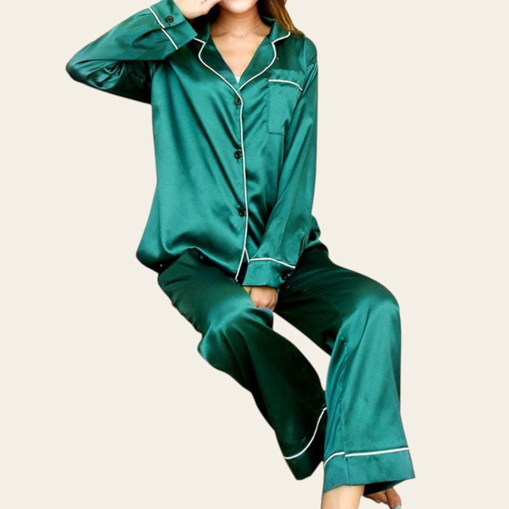 Green satin pajama set with white piping on a white background
