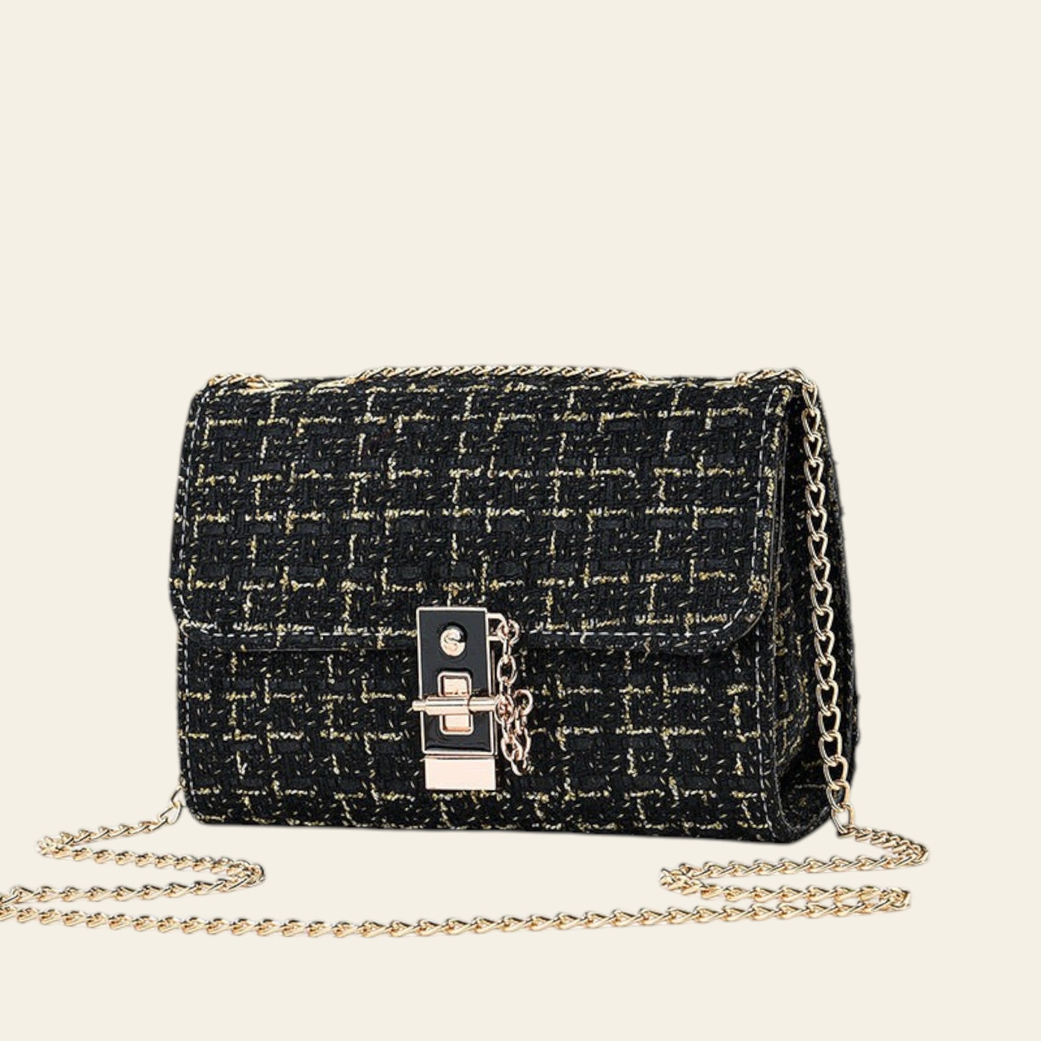 Black textured handbag with gold chain strap on a light gray background