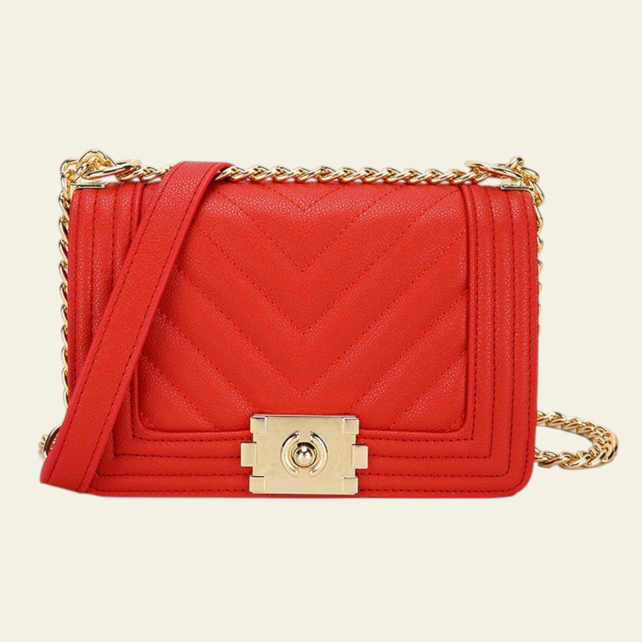 Red handbag with gold chain strap and clasp on a white background