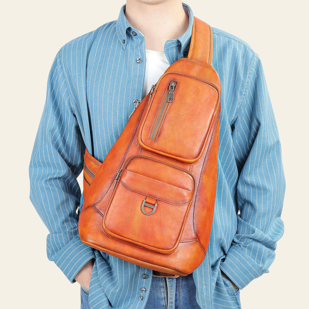 Person wearing an orange leather sling bag against a light blue background