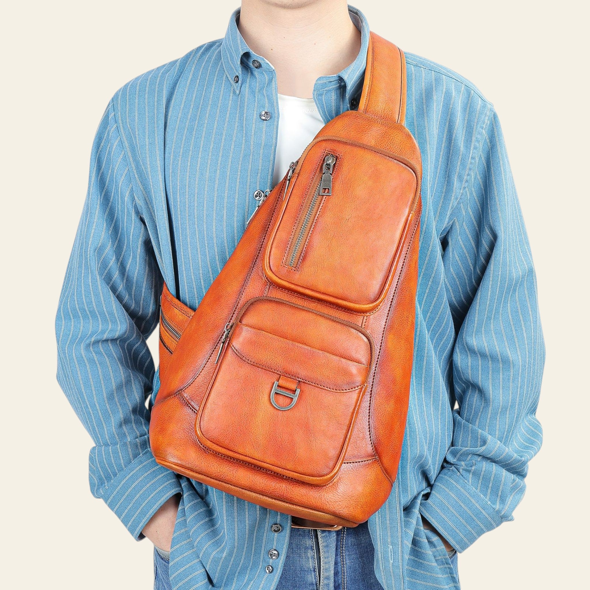Person wearing an orange leather sling bag against a light blue background