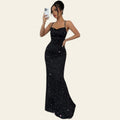 Woman wearing a black backless sequin maxi slip dress