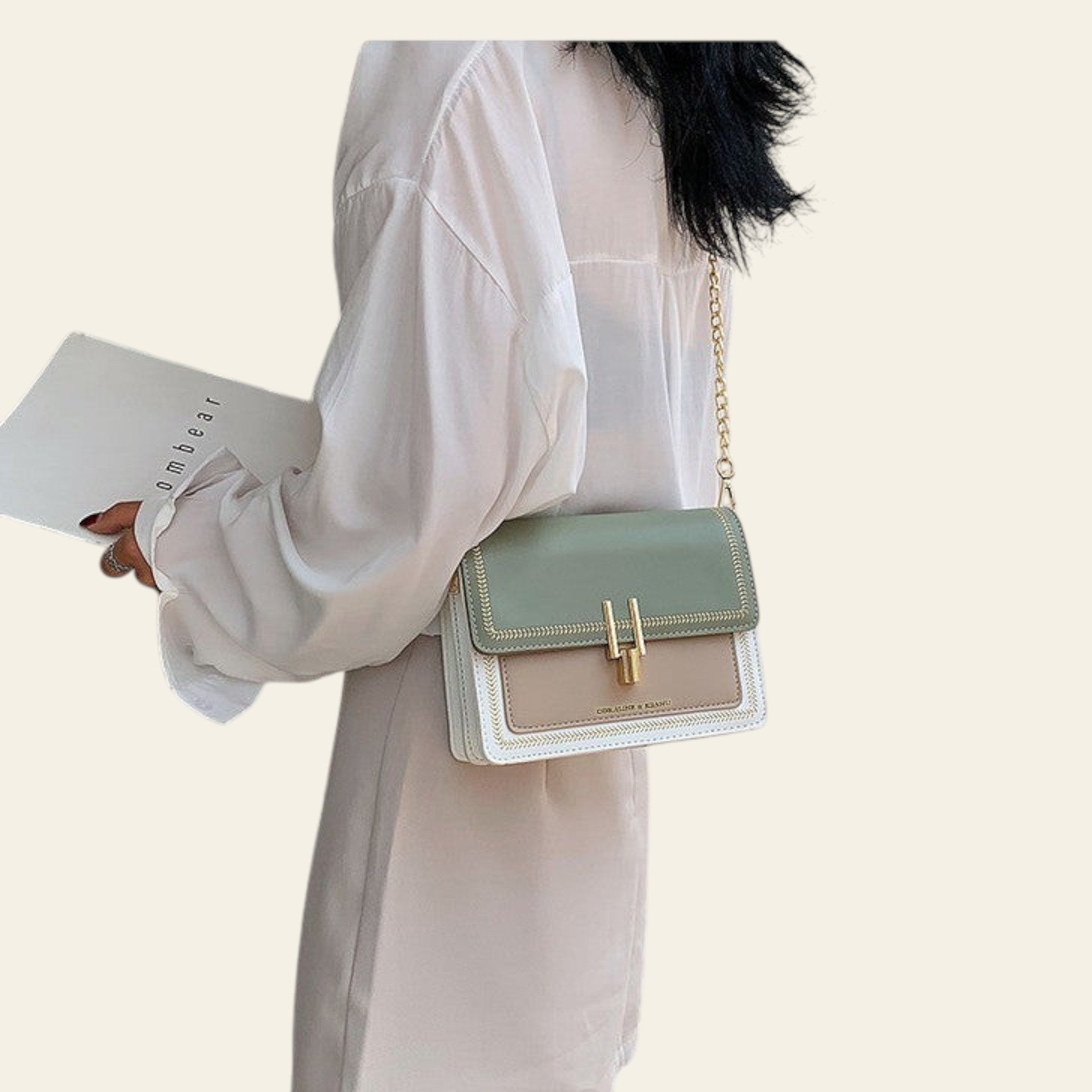 Person holding a light green handbag with a white background