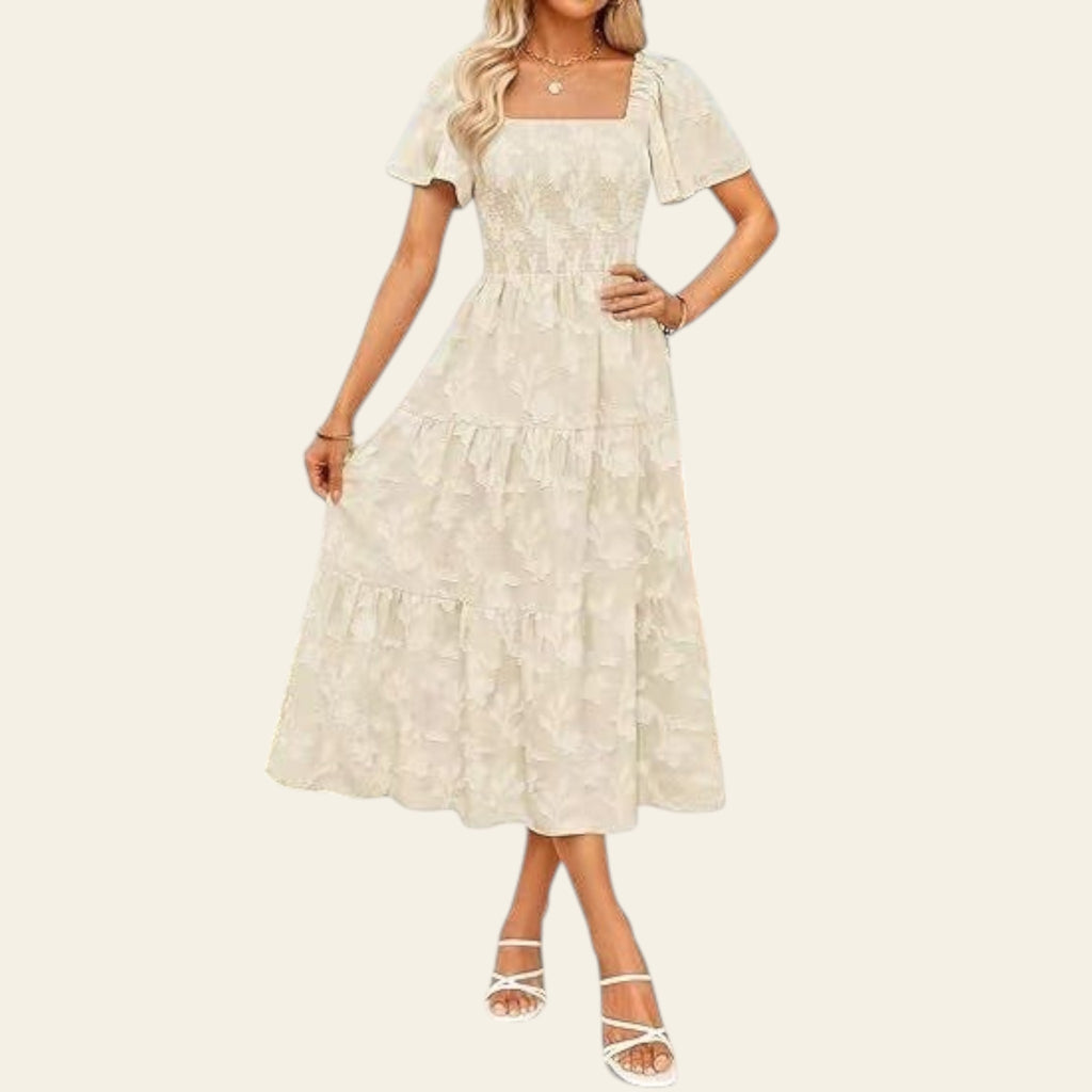 Woman wearing a white lace dress standing outdoors with a blurred background