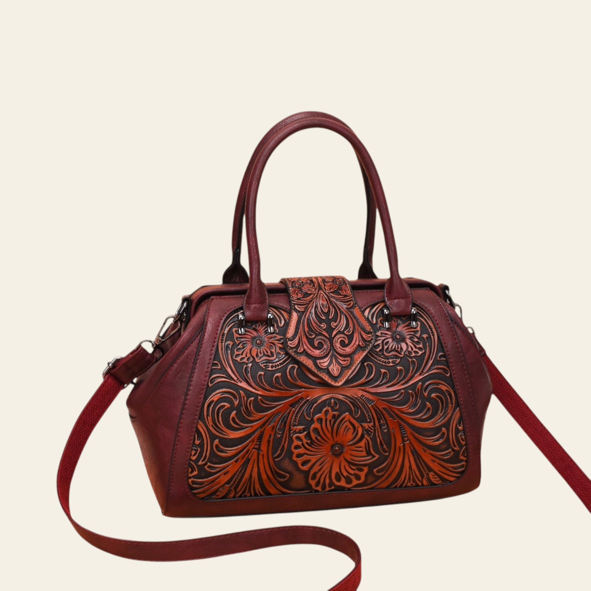 Brown leather handbag with intricate floral patterns on a white background