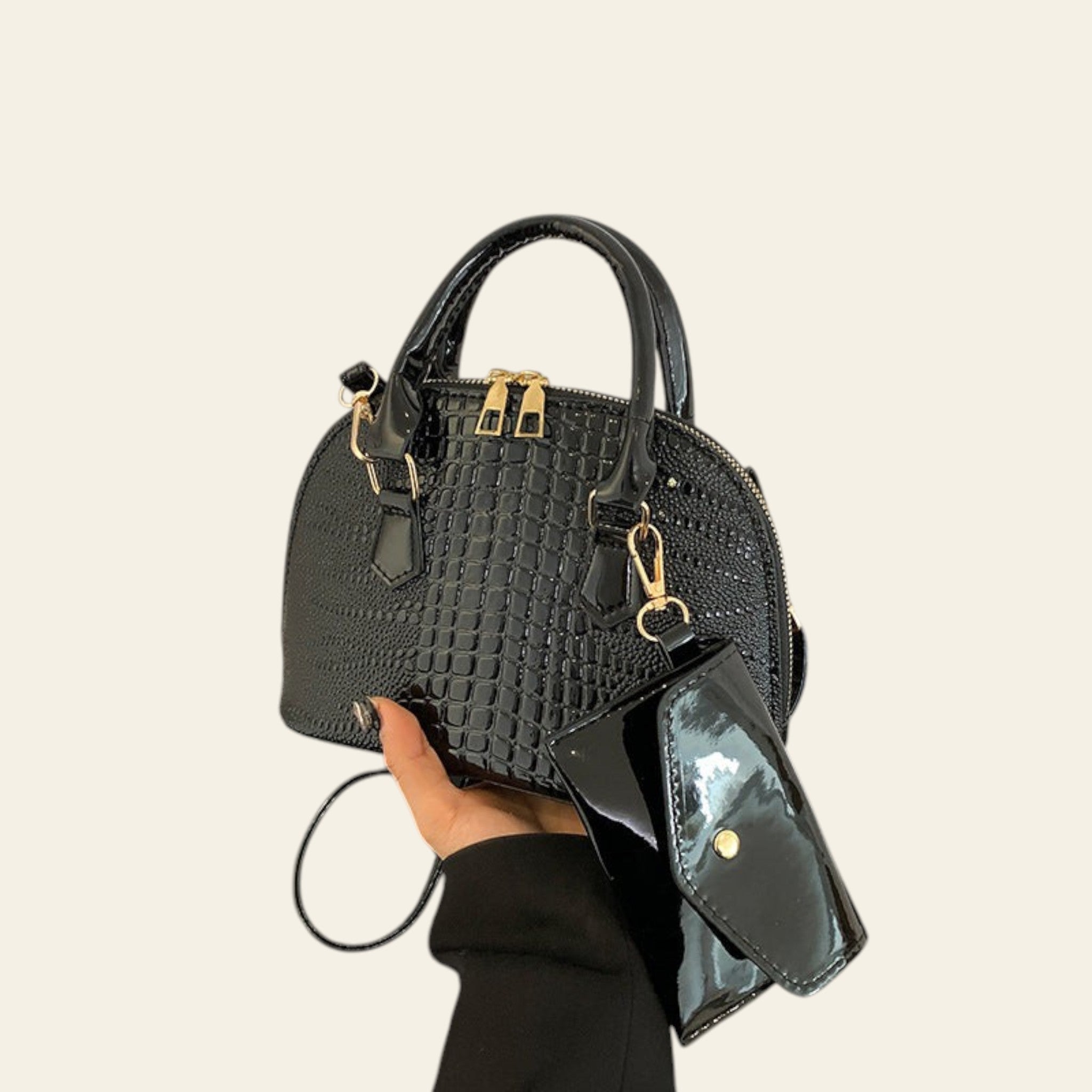 Black textured leather handbag with gold accents and top handle