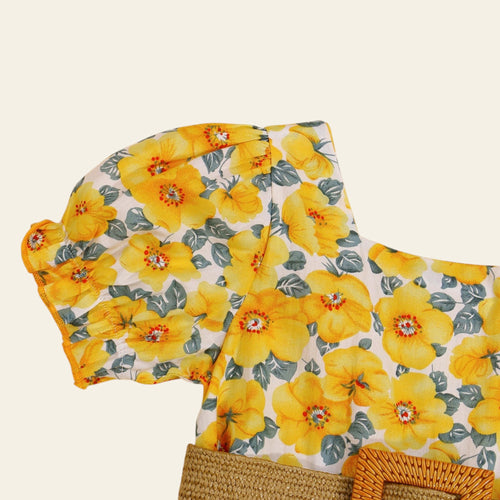Floral-patterned fabric with yellow flowers on a beige background