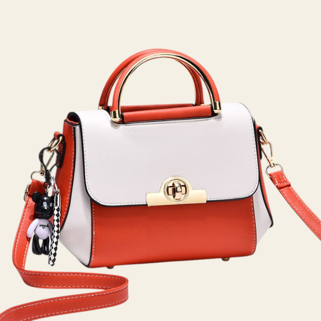 White and red handbag with gold accents on a light gray background